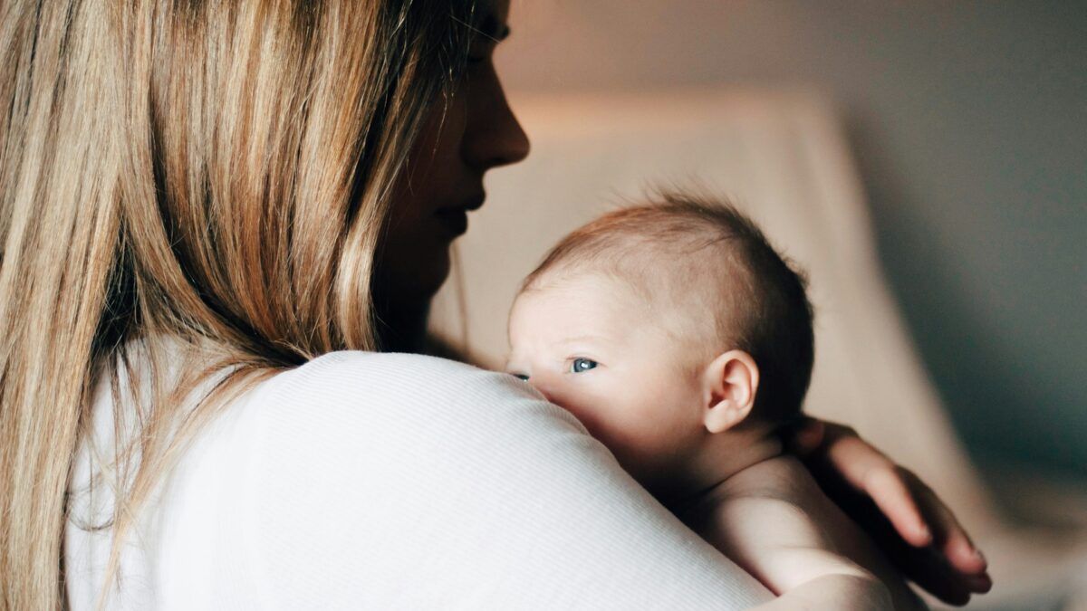 woman carrying newborn baby